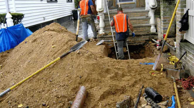 Contractors performing foundation protection and exterior drainage excavation near residential home steps in Bradenton, FL
